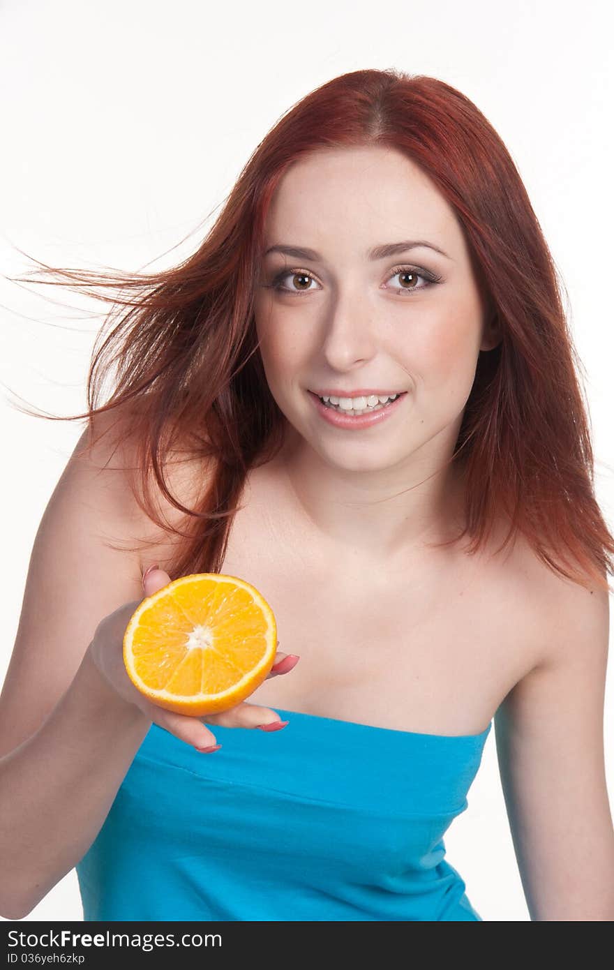 A beautiful redhead woman holding a half of orange isolated on white. A beautiful redhead woman holding a half of orange isolated on white