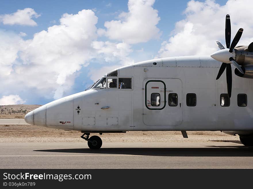 Airplane with propellers landing on a desert airport