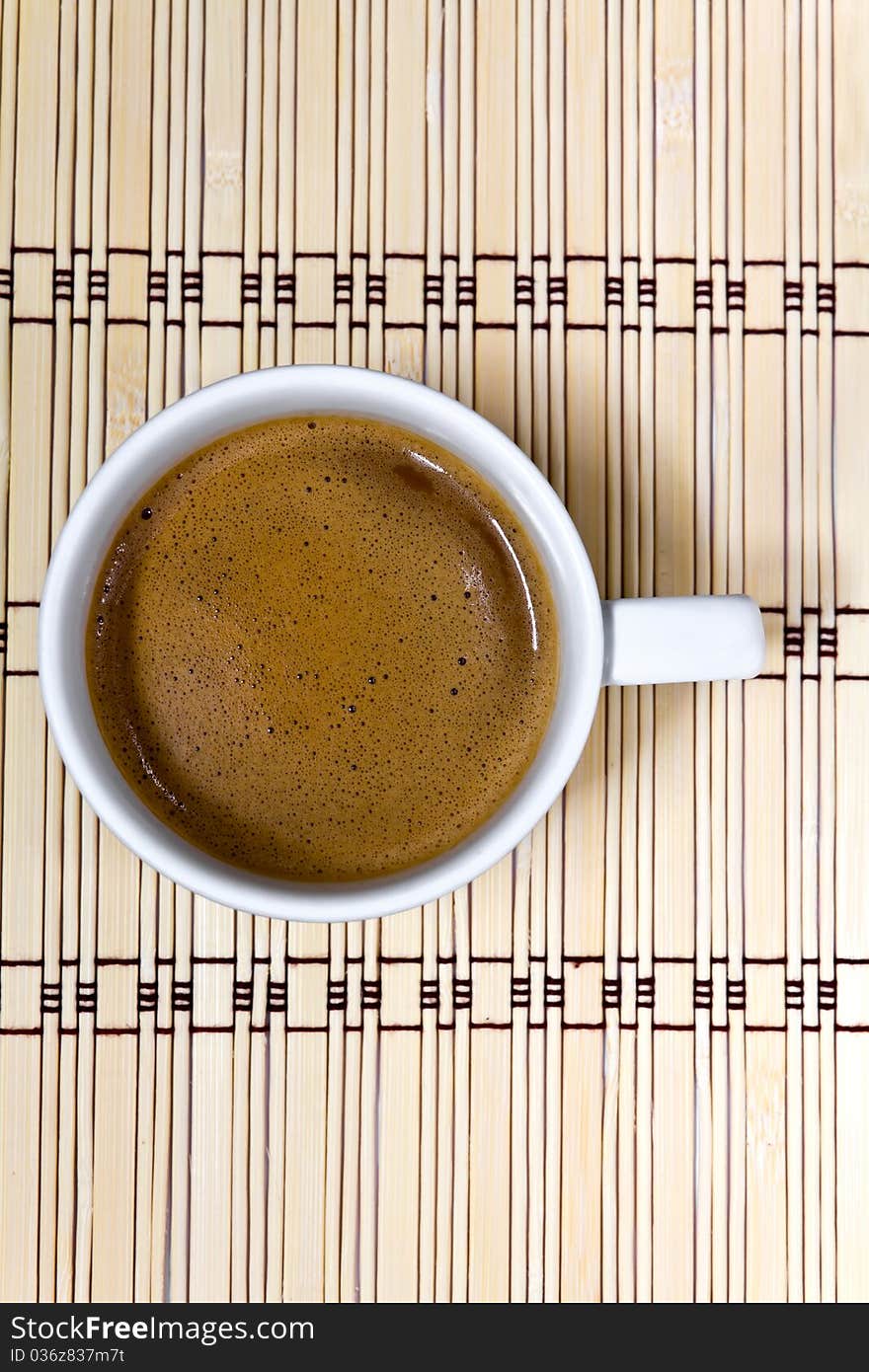 Coffee cup on a mat made of bamboo