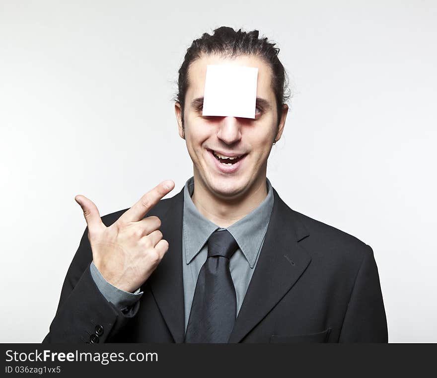 Young man with blank note on the face on white