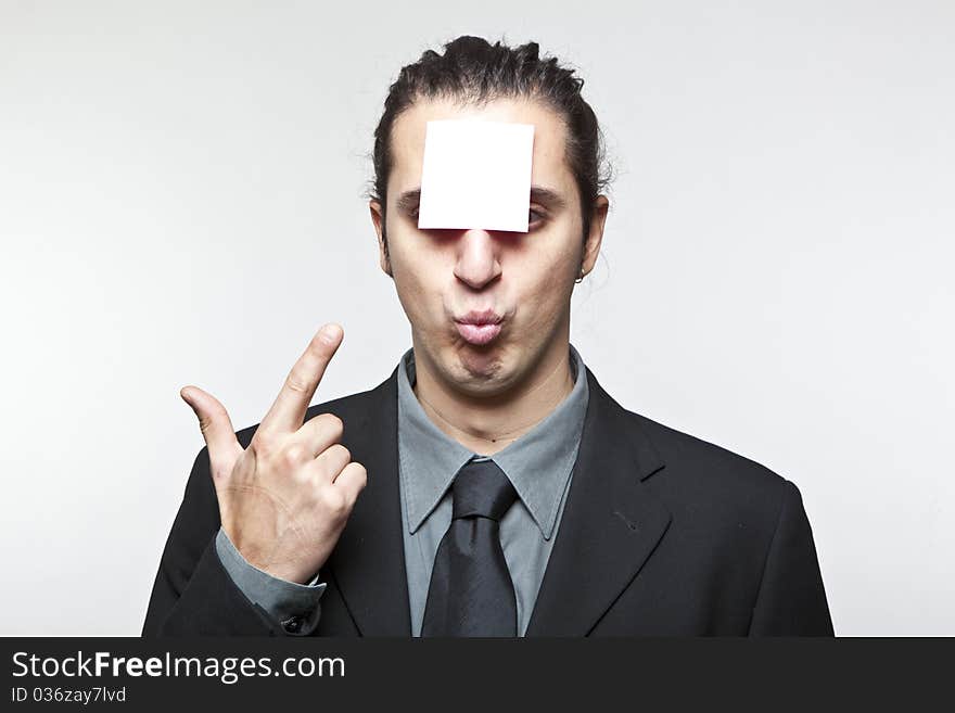 Young man with blank note on the face on white