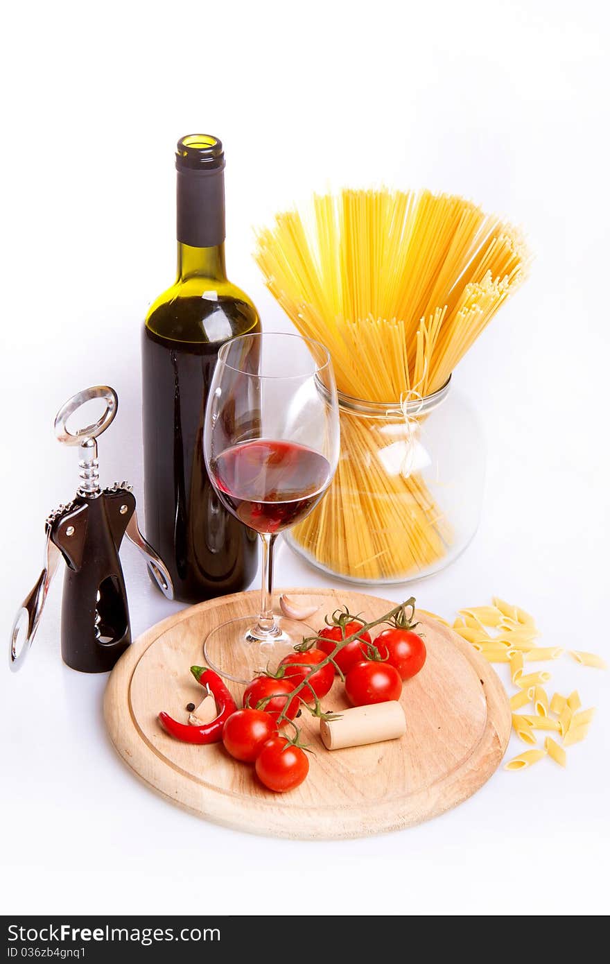 Glass of red wine near italian spaghetti and vegetables for pasta. Glass of red wine near italian spaghetti and vegetables for pasta