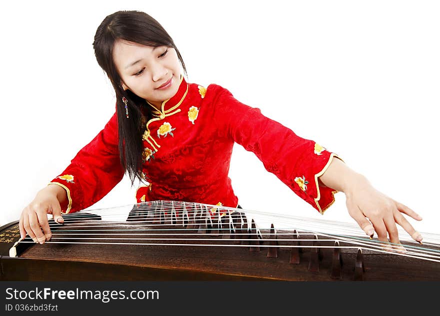 Chinese zither performer in traditional dress playing zither on white. Chinese characters on Chinese zither are Chinese poems. Chinese zither performer in traditional dress playing zither on white. Chinese characters on Chinese zither are Chinese poems.