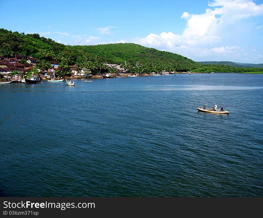 A scene of a beautiful lake with a small boat cruising toward distant mountain. A scene of a beautiful lake with a small boat cruising toward distant mountain.