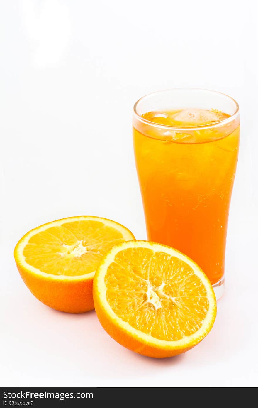 Orange juice in glass with half cut fresh oranges