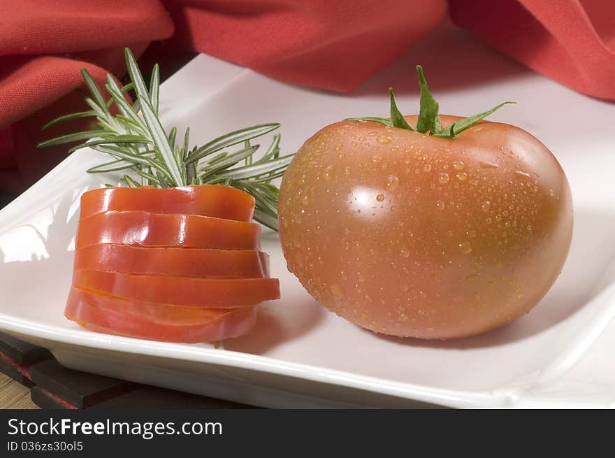 Tomato white plate decorated with tomato slices. Tomato white plate decorated with tomato slices