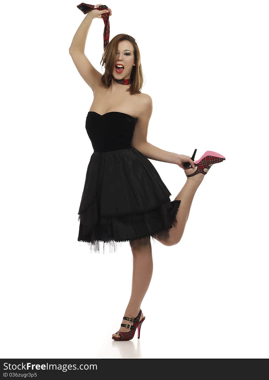 Young girl in little black dress with happy expression pulling up her neck tie. Young girl in little black dress with happy expression pulling up her neck tie