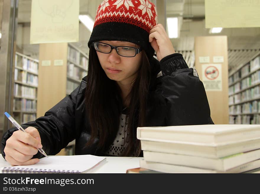 An Asian girl who is reading and studying