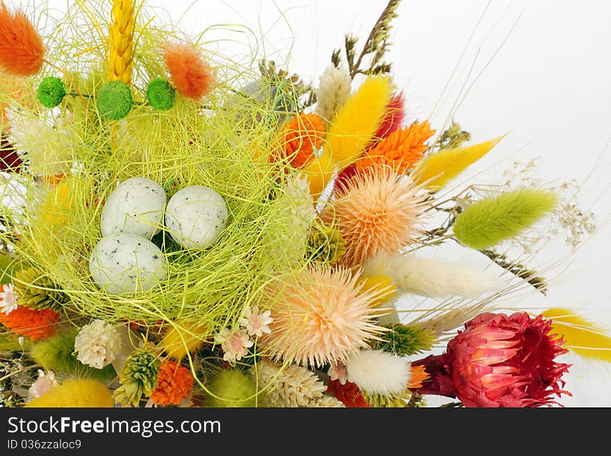 Three cute little quail eggs on colorful dry flowers - Easter decoration background