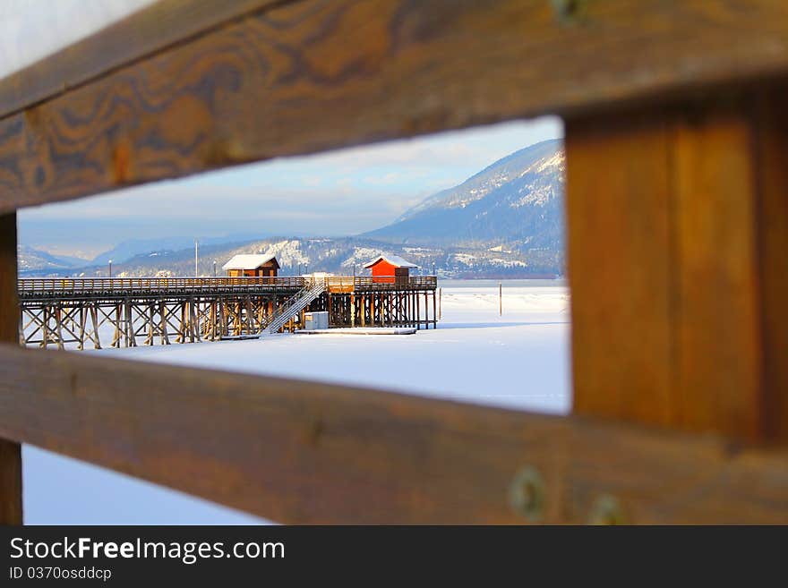 Wooden pier with snow at frozen lake in Salmon Arm