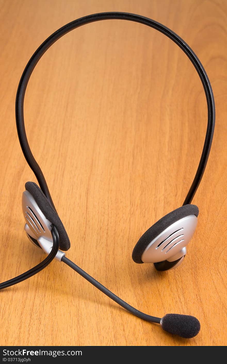 Computer headset on wooden office desk. Computer headset on wooden office desk