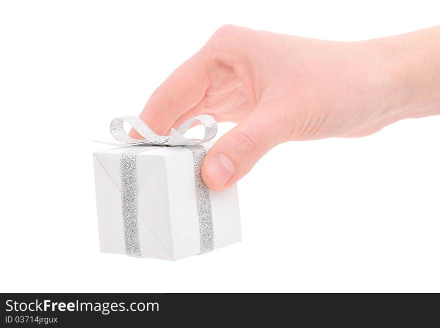 Woman's hand with a small white gift box with silver ribbon isolated on white background. Woman's hand with a small white gift box with silver ribbon isolated on white background.