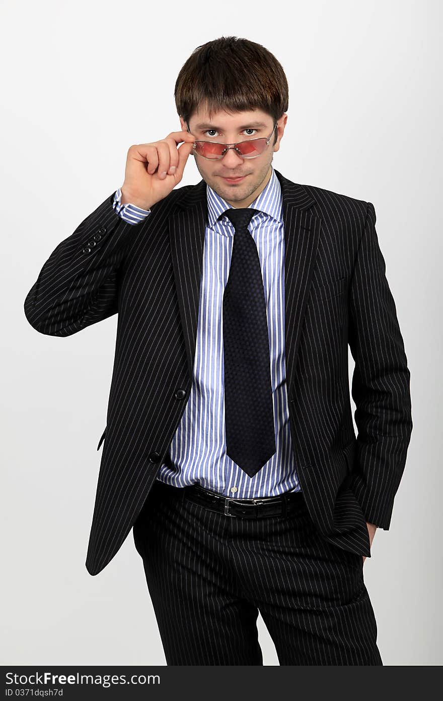 A business man in a suit adjusts glasses. A business man in a suit adjusts glasses