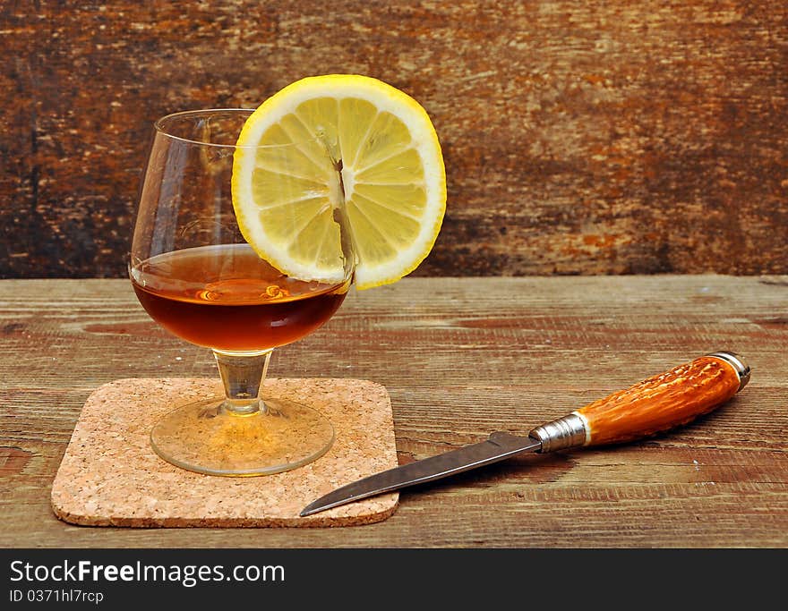 Classic cognac with lemon and knife