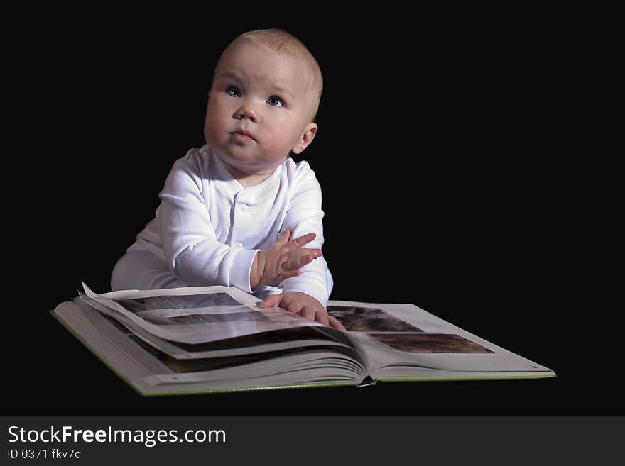 The kid sitting on the floor and read a great book