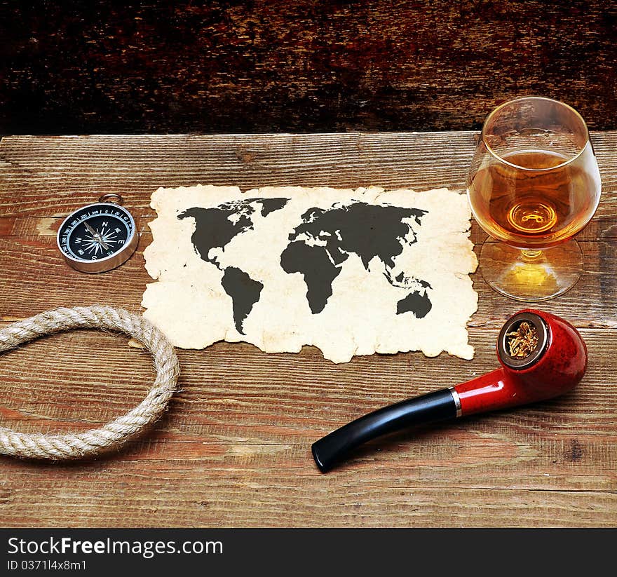 Old paper, pipe and glass of cognac on wood background