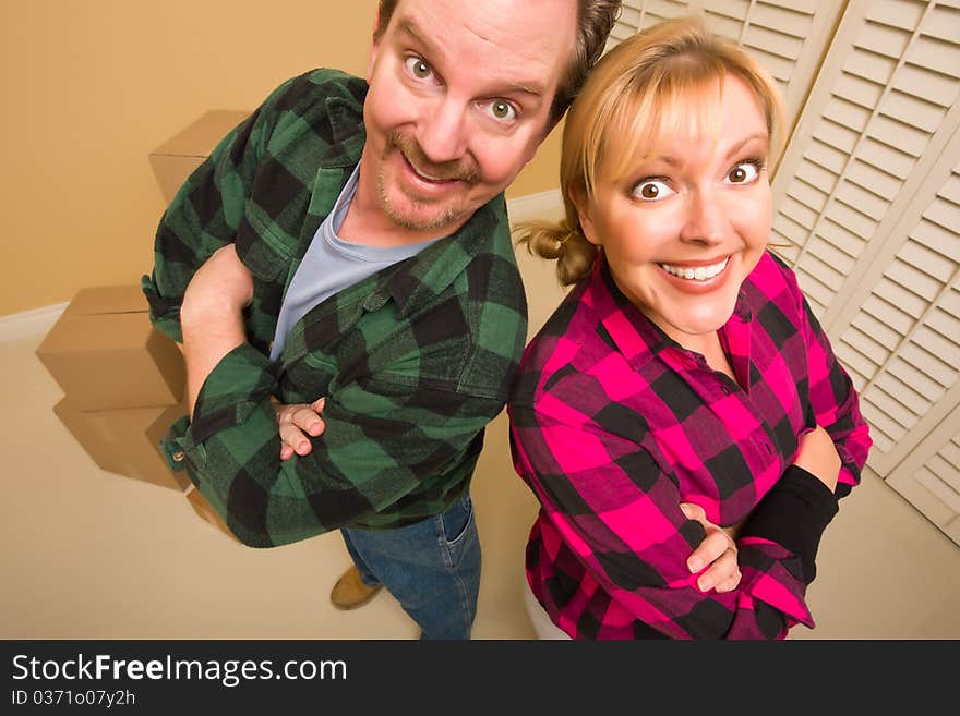 Proud Smiling Goofy Couple and Moving Boxes in Empty Room. Proud Smiling Goofy Couple and Moving Boxes in Empty Room.