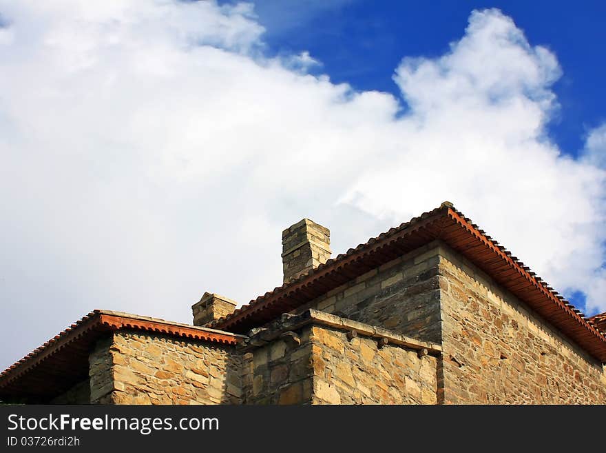 Old stone house against the blue sky with clouds in the medieval town