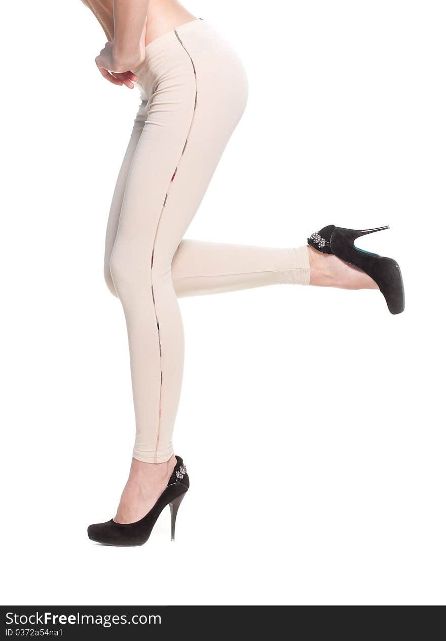 Close up of woman legs in fawn leggins and black shoes on white