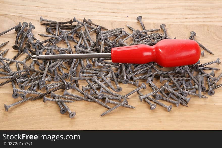 A pile of old screws and pliers closeup to the background of the tree