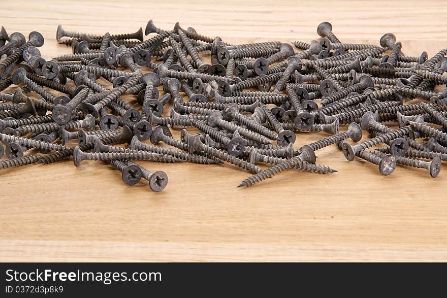 A pile of old screws closeup to the background of the tree