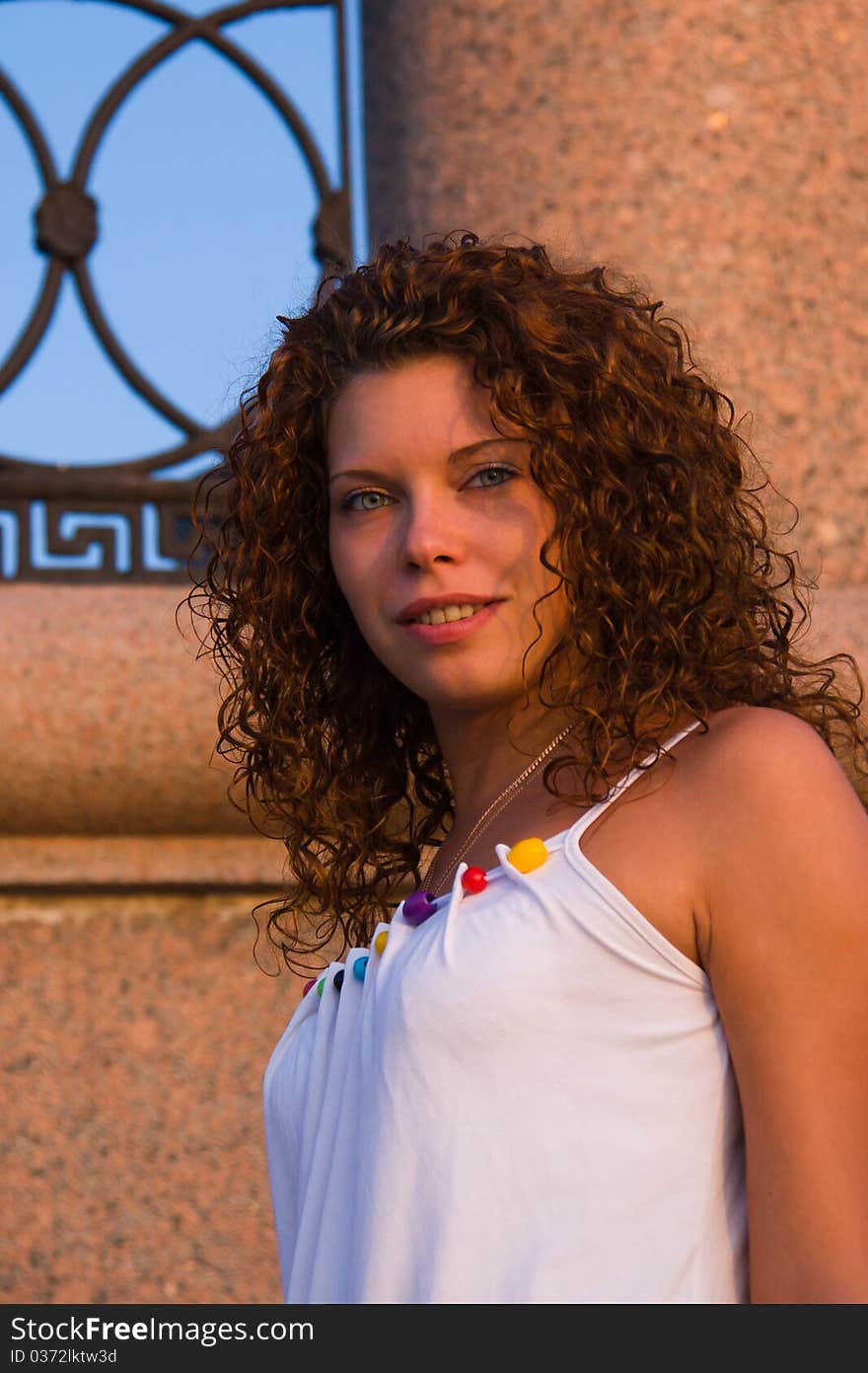 Curly beautiful girl with wall on background