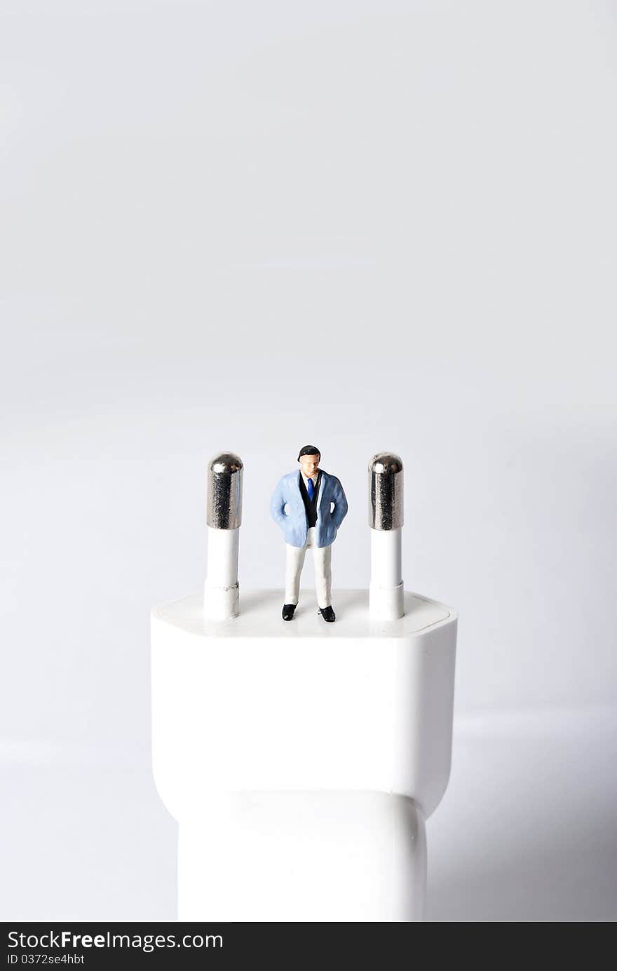 Miniature man on power plug. Miniature man on power plug