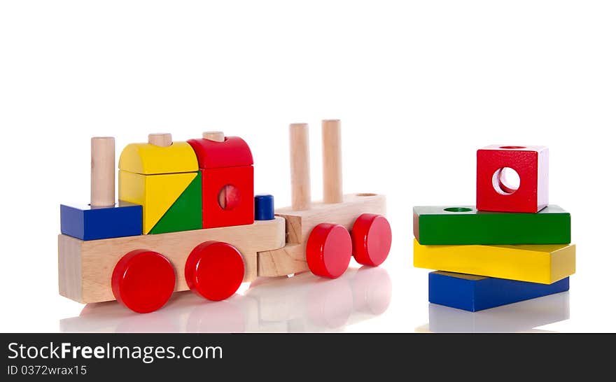 Stacked wooden toy blocks and an educative wooden train isolated over white. Stacked wooden toy blocks and an educative wooden train isolated over white