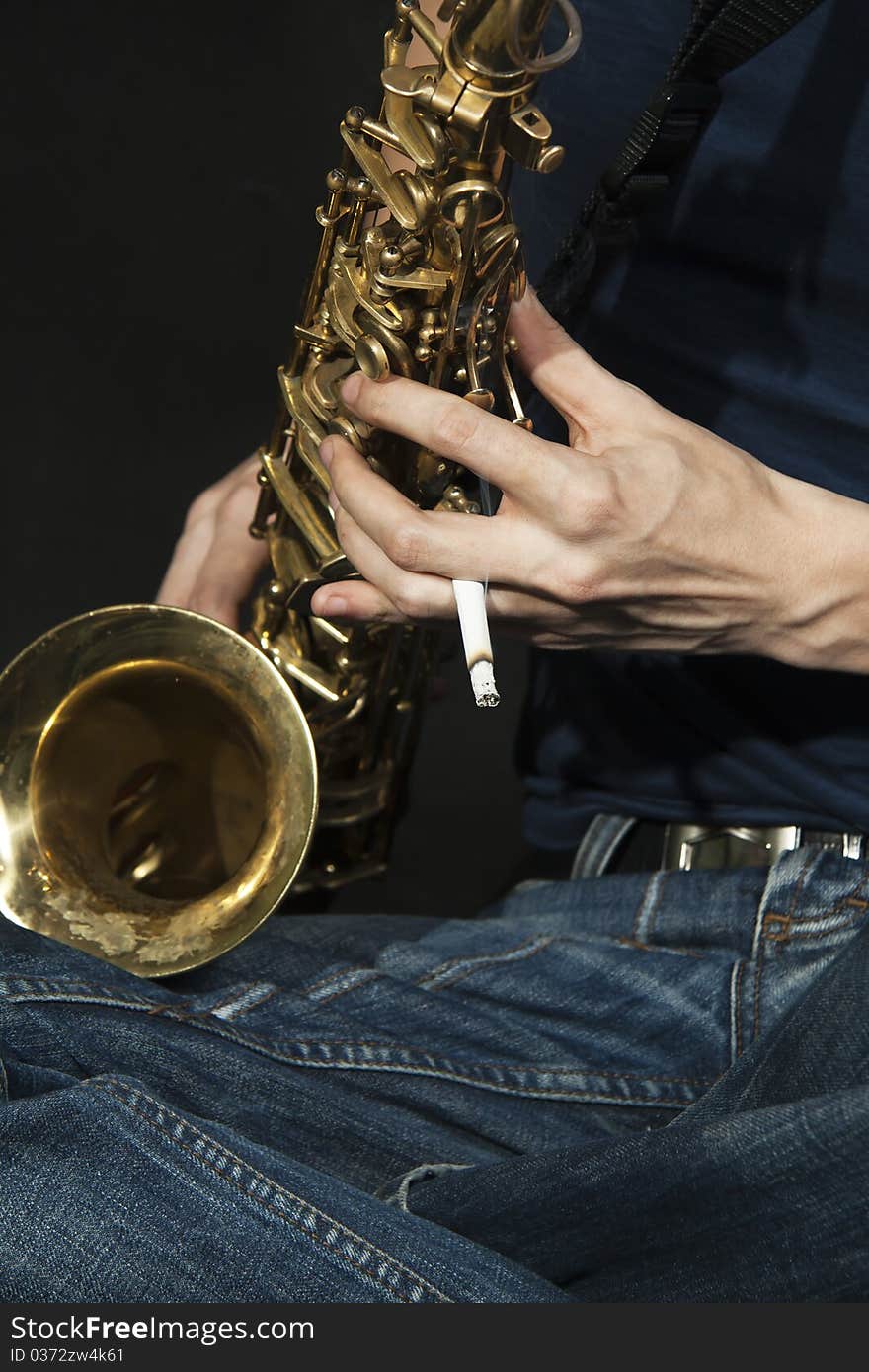 Close-up  cross-legged jazzman plays a saxophone