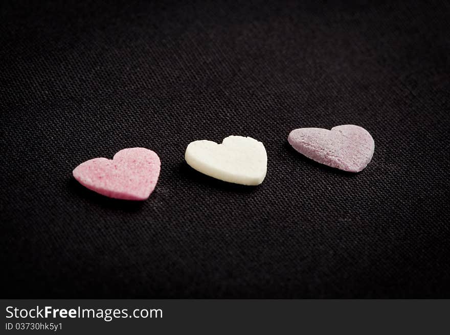 Heart shaped candy sweets on black bakground