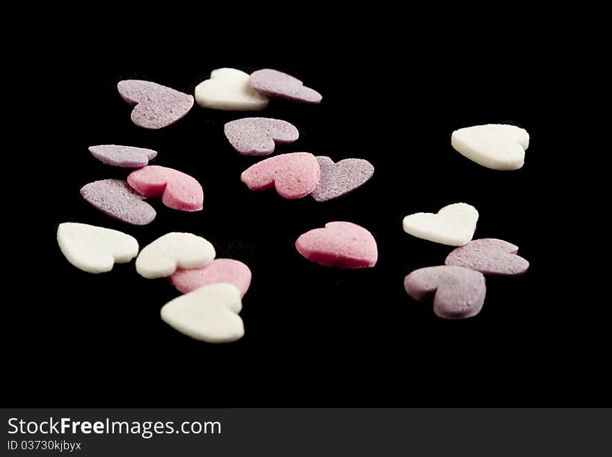 Heart shaped candy sweets on black bakground