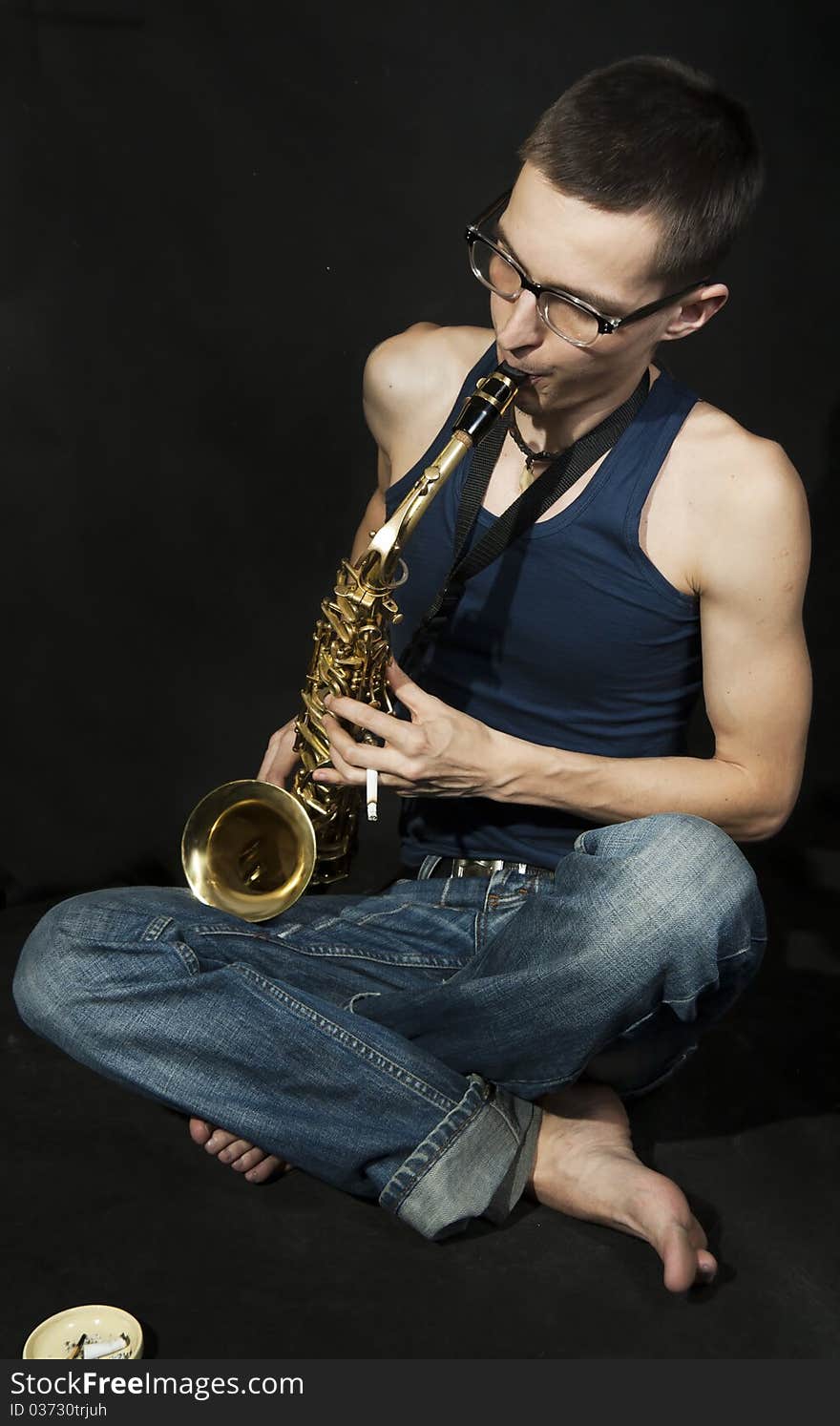 Cross-legged Jazzman Plays A Saxophone