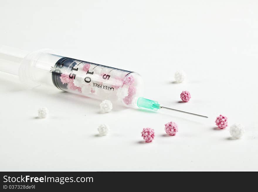 Syringe filled with heart shaped candy on a white background