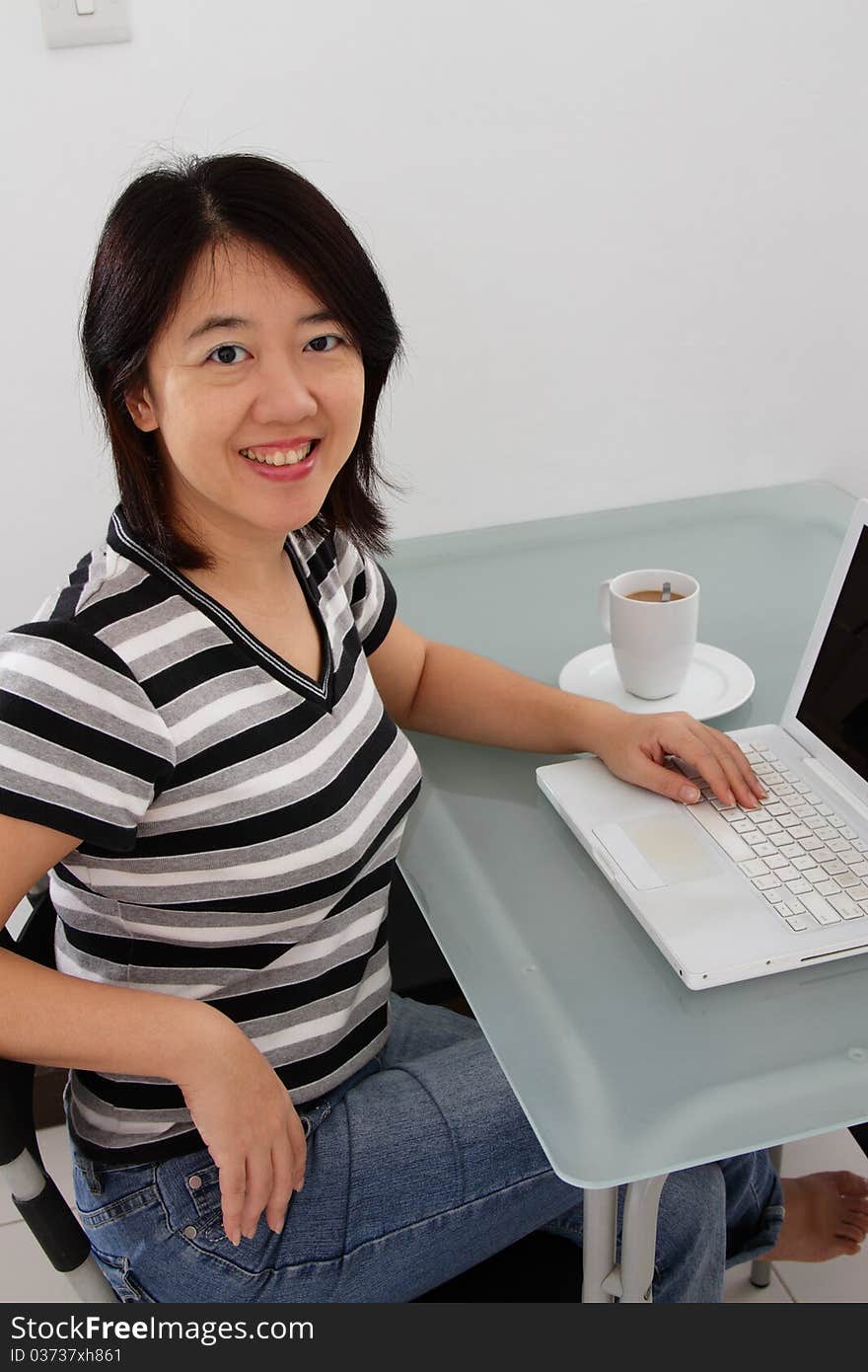 An Asian woman working at home. An Asian woman working at home