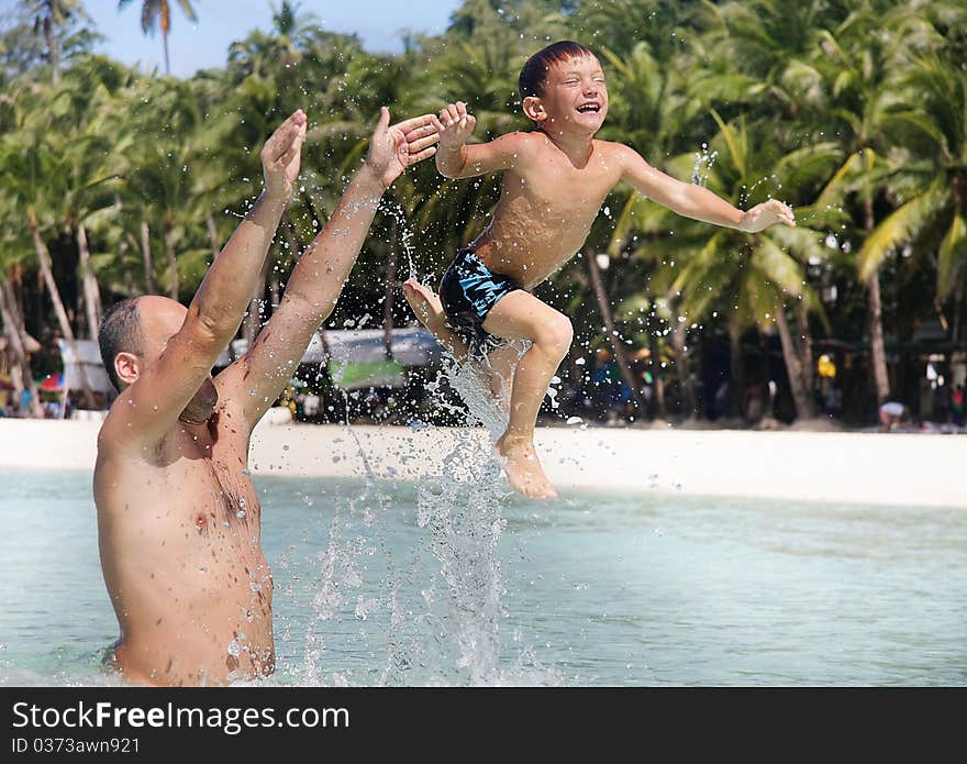 Father and son playing in water. Father and son playing in water