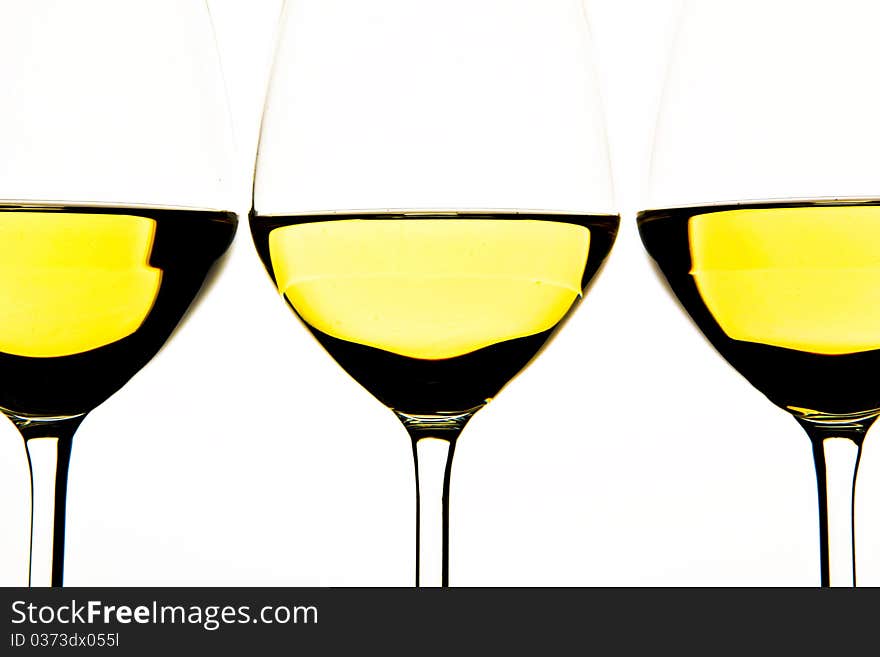 Three glasses of white wine on white background