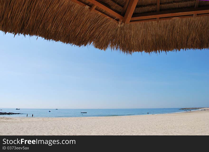 Look at the sea under beach bamboo umbrella. Look at the sea under beach bamboo umbrella