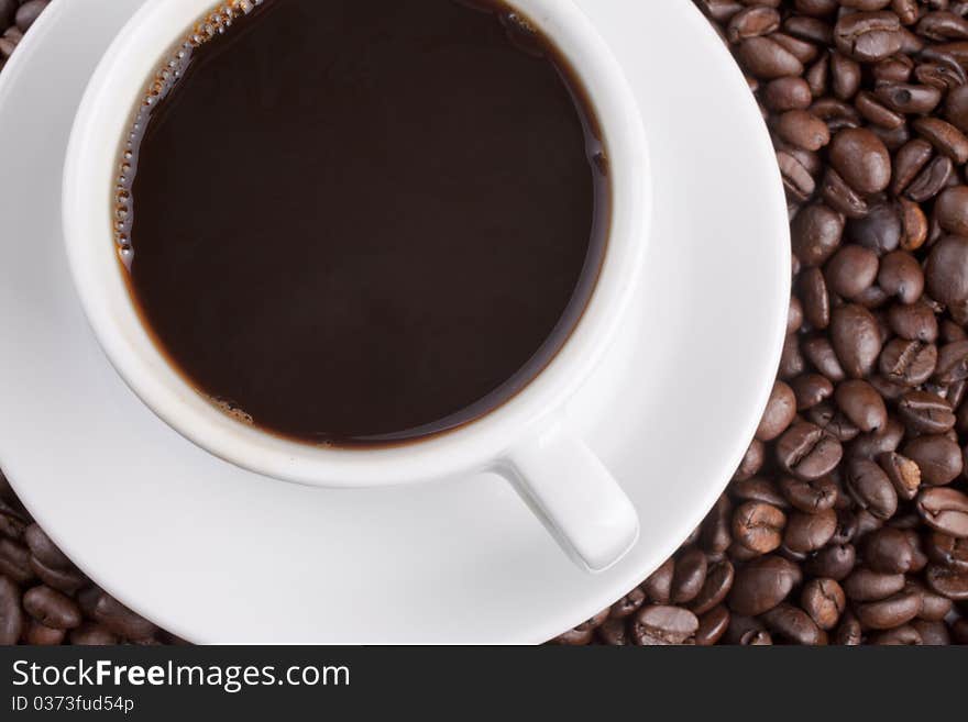 White cup with coffee on a grains background