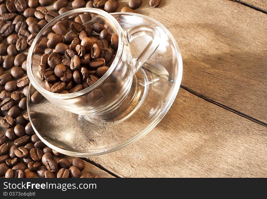 Coffee cup and grain and grains are scattered on the wooden surface