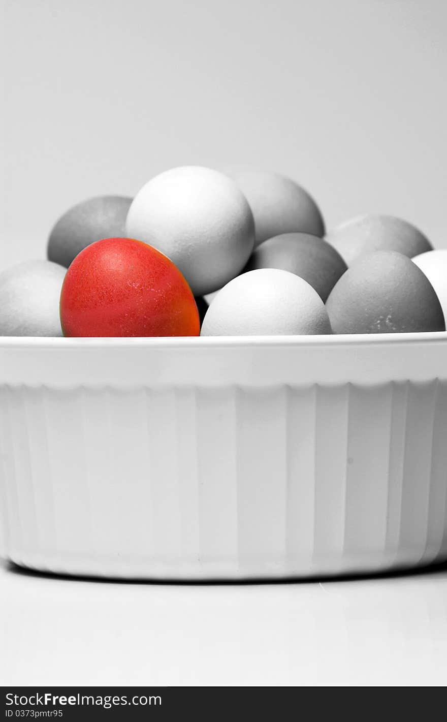 One red Easter egg in bowl with gray ones. One red Easter egg in bowl with gray ones.