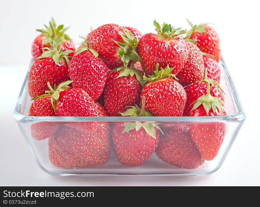 Strawberries in the glass bowl on white background