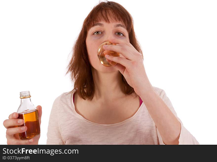 A young woman is drinking hard liquor and has a bottle in her hand. A young woman is drinking hard liquor and has a bottle in her hand