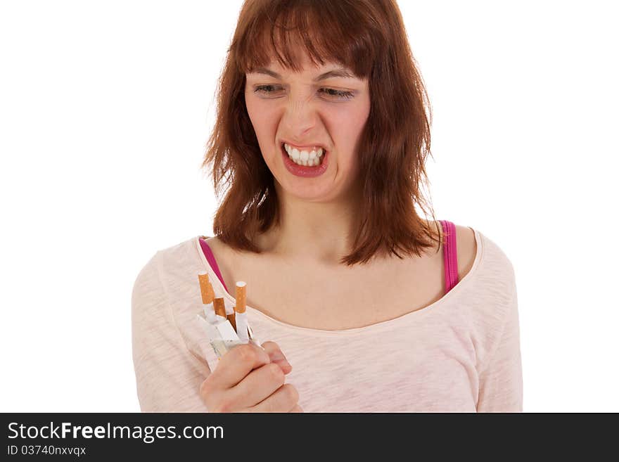 A young woman is angrily screwing up a pack of cigarettes. A young woman is angrily screwing up a pack of cigarettes