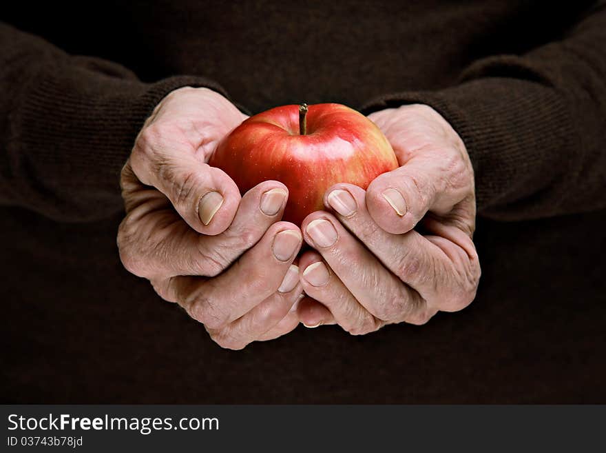 Senior woman holding a red organic apple. Senior woman holding a red organic apple