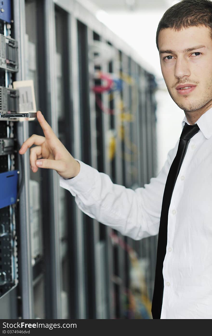 Young handsome business man it engeneer in datacenter server room. Young handsome business man it engeneer in datacenter server room