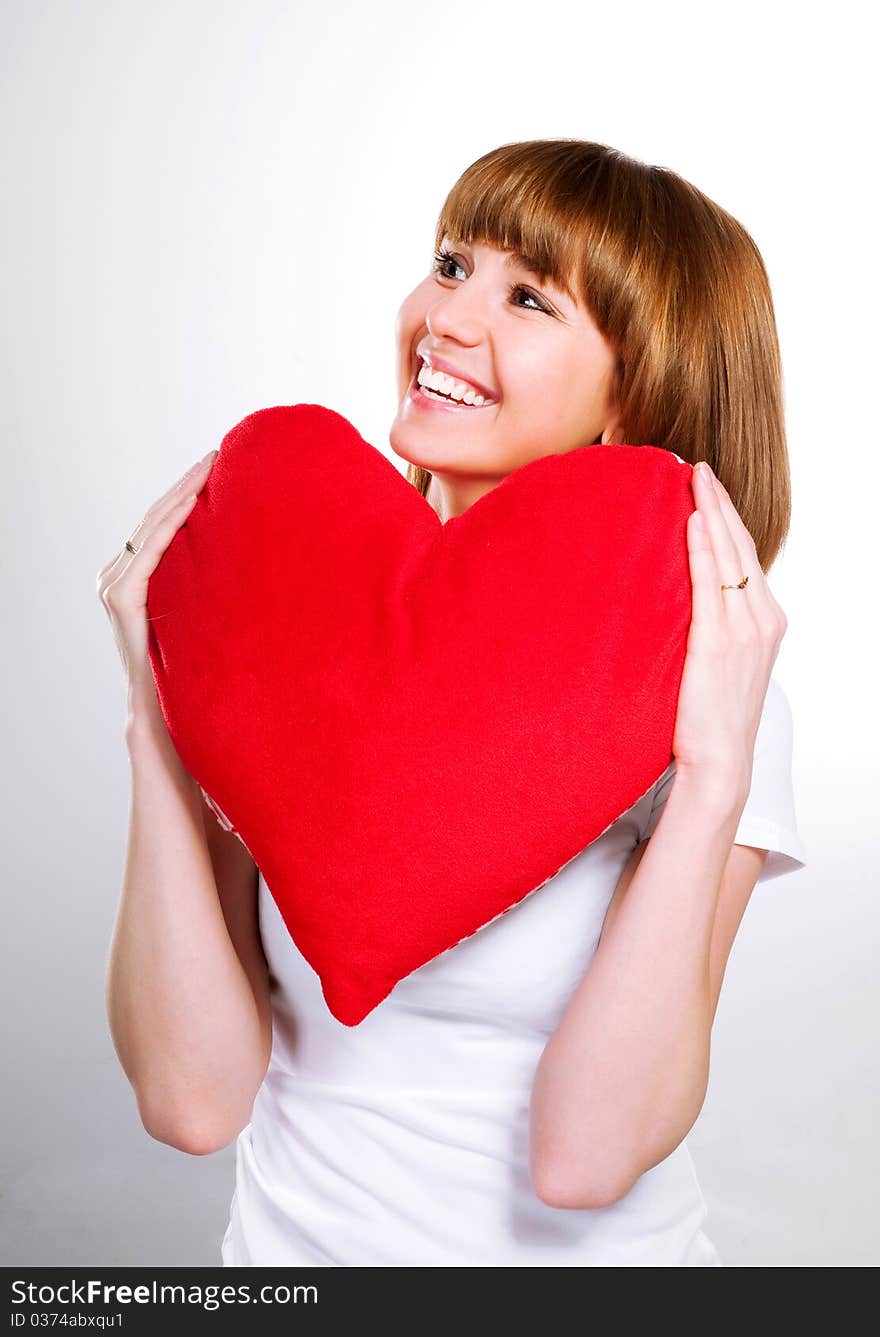 Beautiful young brunette with red heart isolated on white background