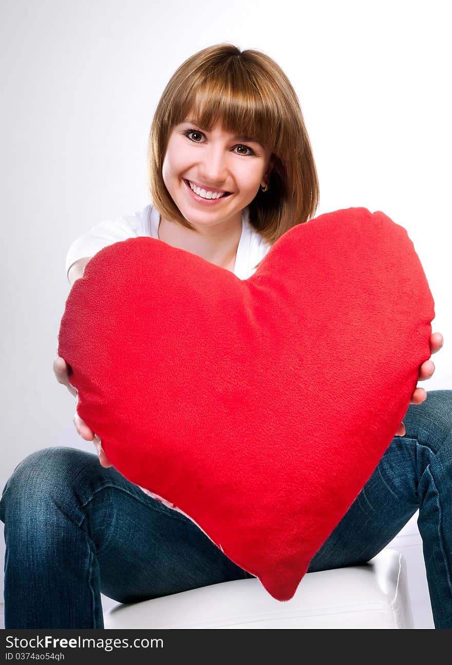 Beautiful young brunette with red heart isolated on white background