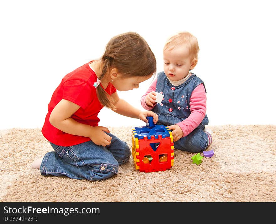 Sisters playing on the floor with cube toy. Sisters playing on the floor with cube toy