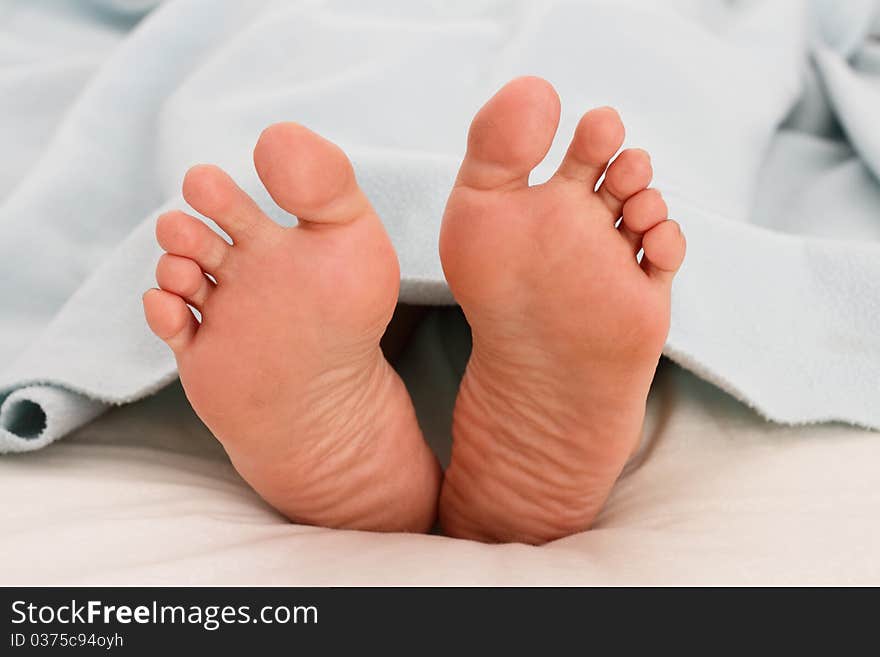 A woman's feet under a blanket