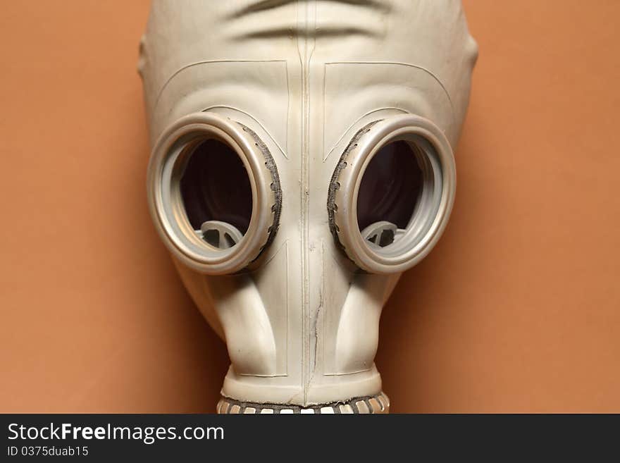 Closeup of old gas mask on orange background. Closeup of old gas mask on orange background